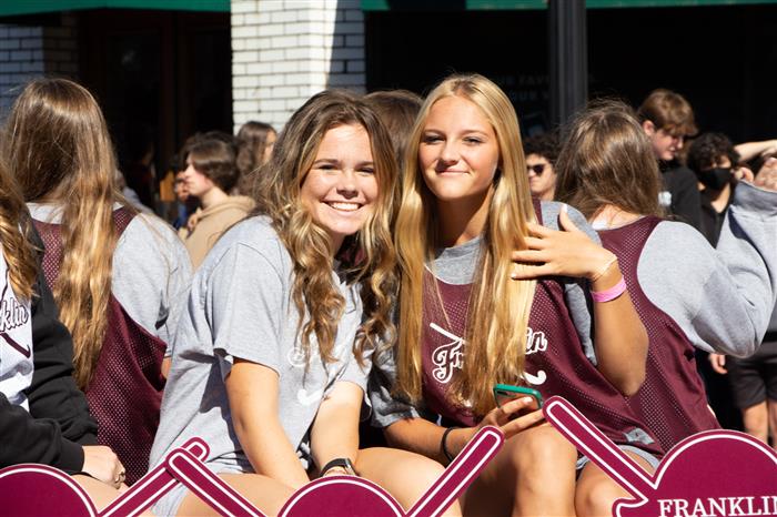 Two girls sitting next to each other wearing Franklin High t-shirts